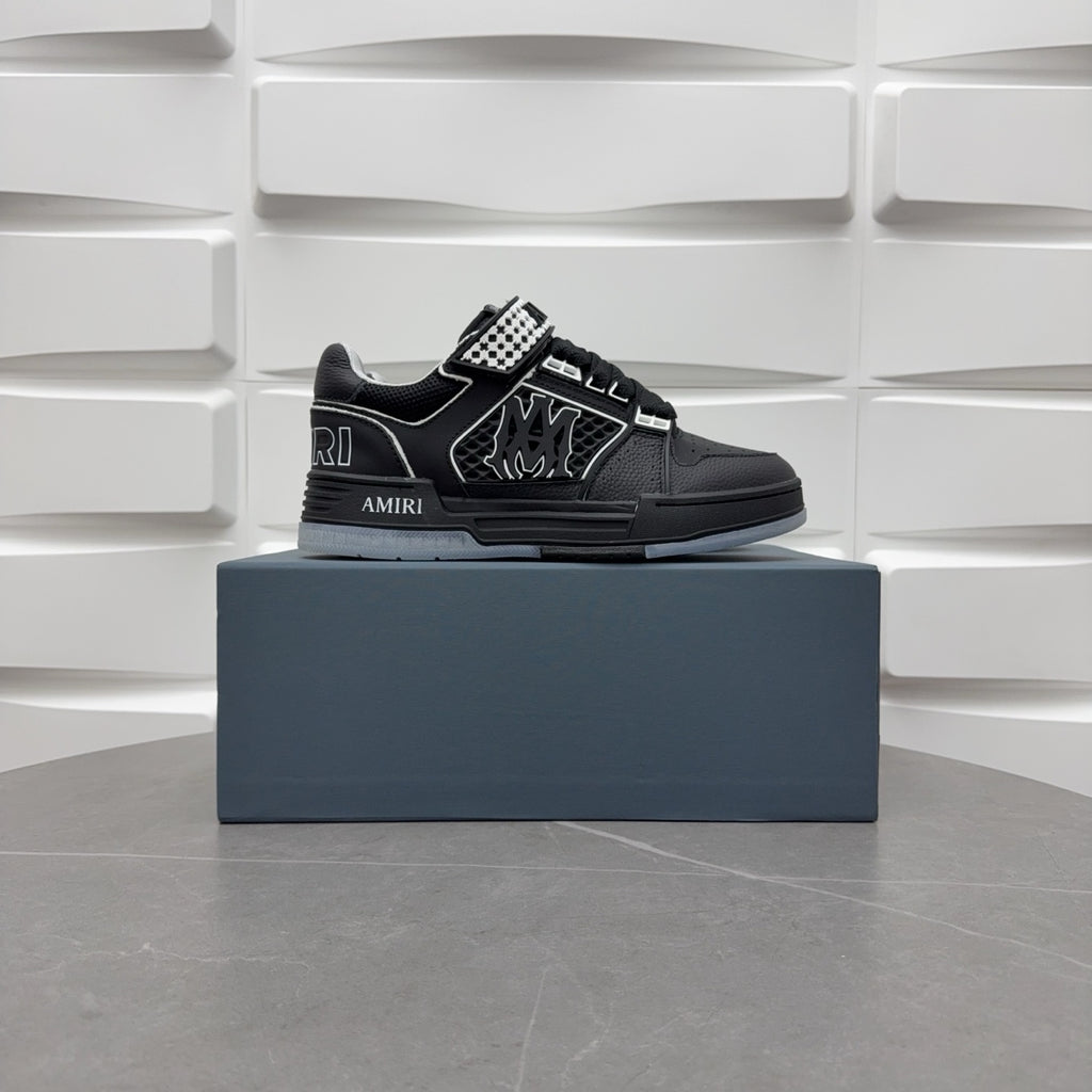 Black low-top sneakers with checkerboard strap and bold graphic logo, on box.