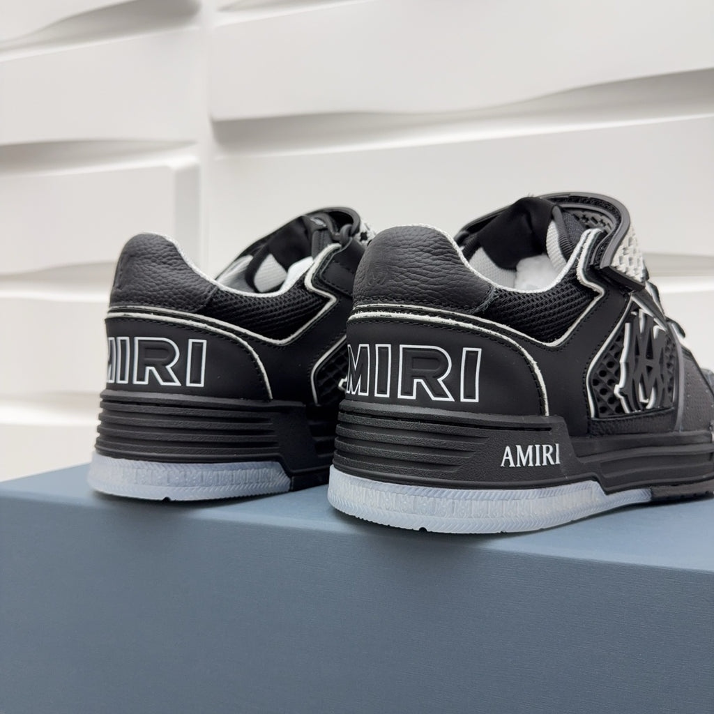 Black low-top sneakers heel and side view with “AMIRI” branding and checker details.