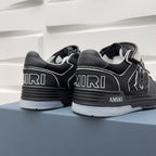 Black low-top sneakers heel and side view with “AMIRI” branding and checker details.
