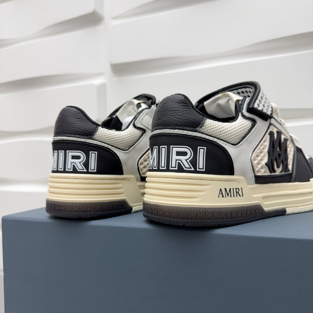 Pair of black and white sneakers with checker trim, AMIRI logo, beige sole.