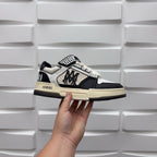 Black and white low-top sneakers, checker strap and lace-up, beige midsole.
