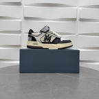 Black and white low-top sneakers with checker strap, lace-up, beige sole.