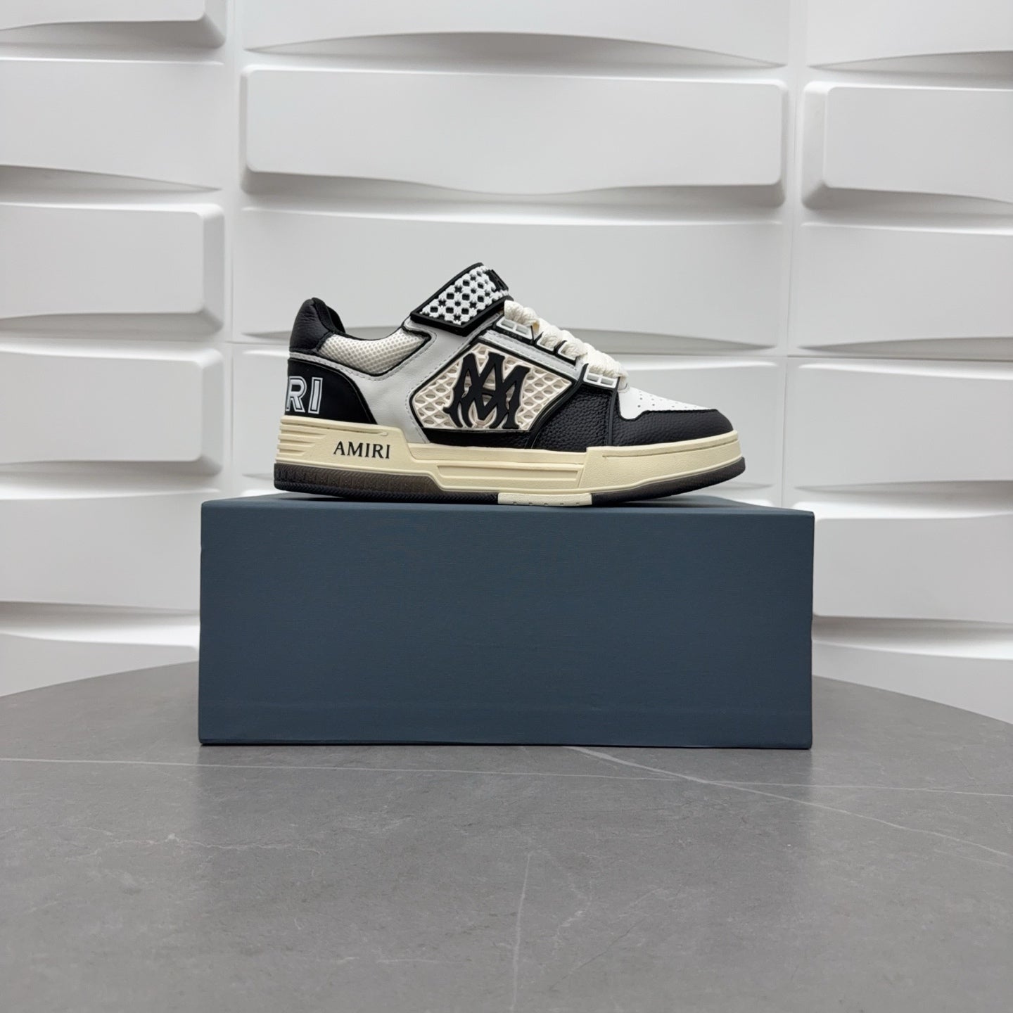 Black and white low-top sneakers with checker strap, lace-up, beige sole.