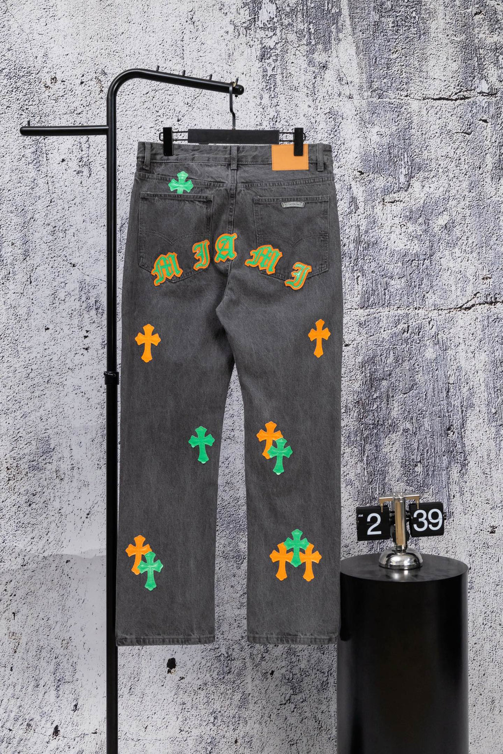 Dark gray denim pants with colorful cross patches and a graffiti-style print