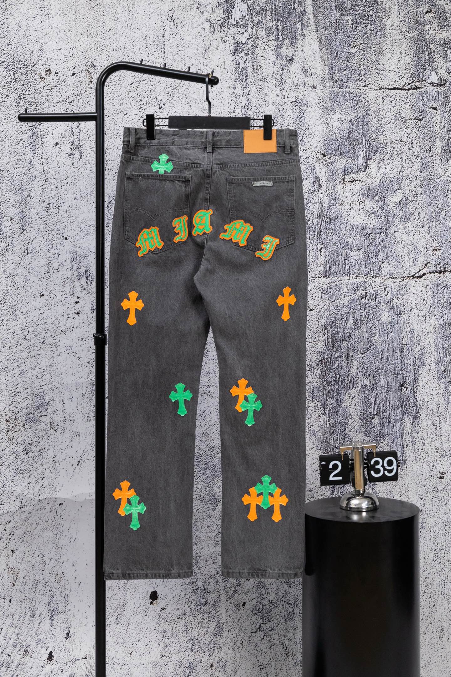 Dark gray denim pants with colorful cross patches and a graffiti-style print
