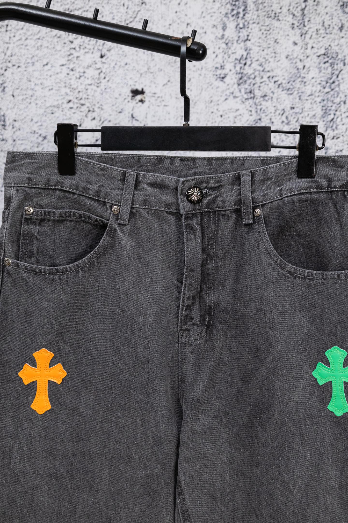 Dark gray denim pants front with belt loops and patchwork cross designs