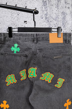 Dark gray denim pants front view with waistband and colorful cross embroidery
