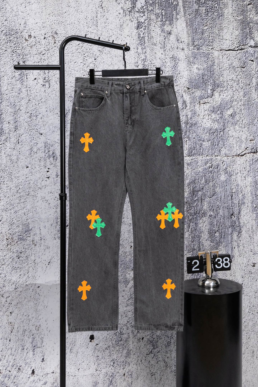 Dark gray denim pants with colorful cross patches on the front legs