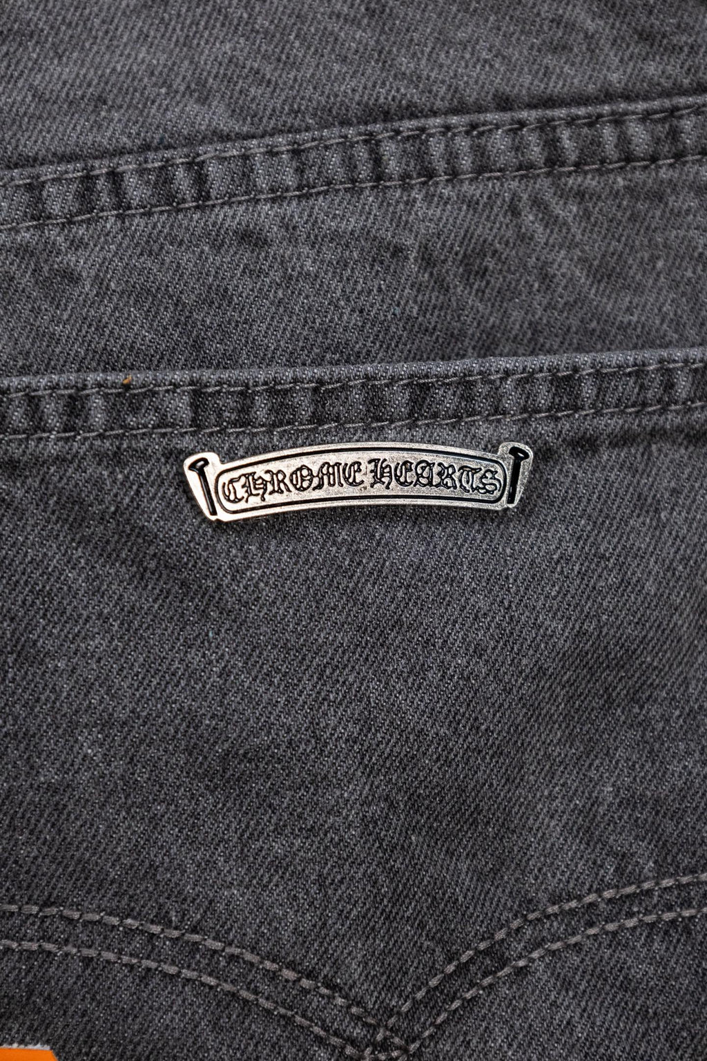 Dark gray denim pants with stitched waistband and logo leather patch