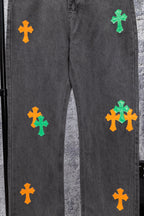 Dark gray denim pants with multiple green and orange cross patches on the legs