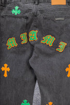 Dark gray denim pants with multiple embroidered symbols across pockets