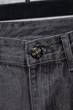 Gray denim pants close-up of decorative snap-button on waistband pocket.