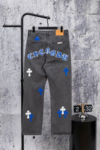 Gray denim pants with blue and white cross patches and orange size tag, front view.