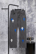 Gray denim pants with blue and white cross patches, front view on hanger.