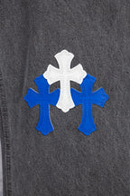 Chrome pants side close-up with blue and white cross applique on dark denim