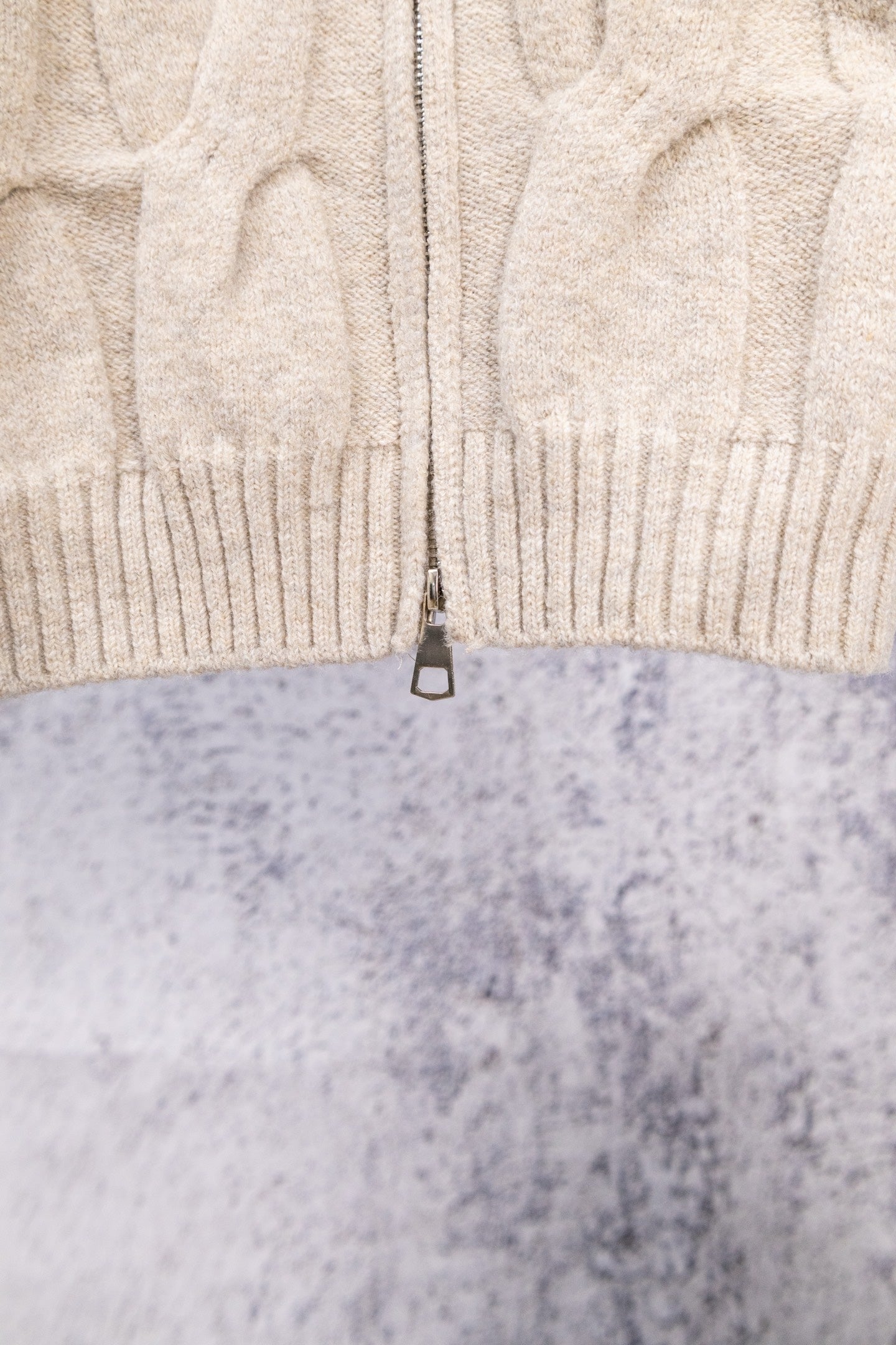 Cream ribbed knit sweater with center-front zipper and textured cable pattern