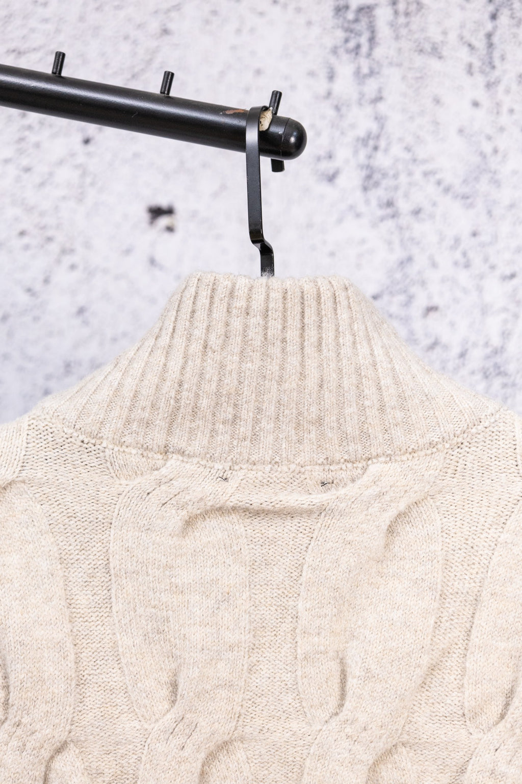 Cream knit sweater neckline and cable pattern, stand collar view