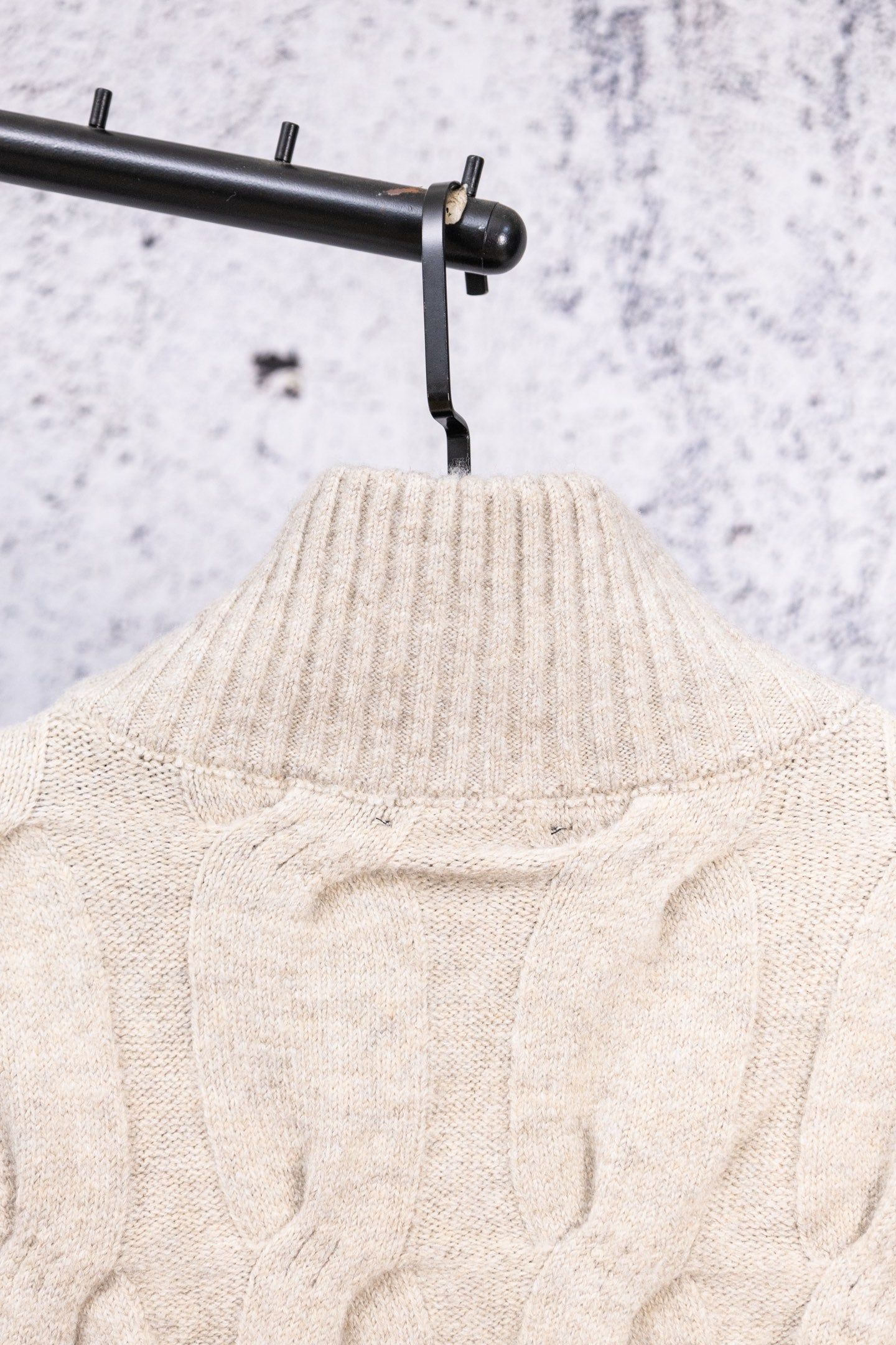 Cream knit sweater neckline and cable pattern, stand collar view