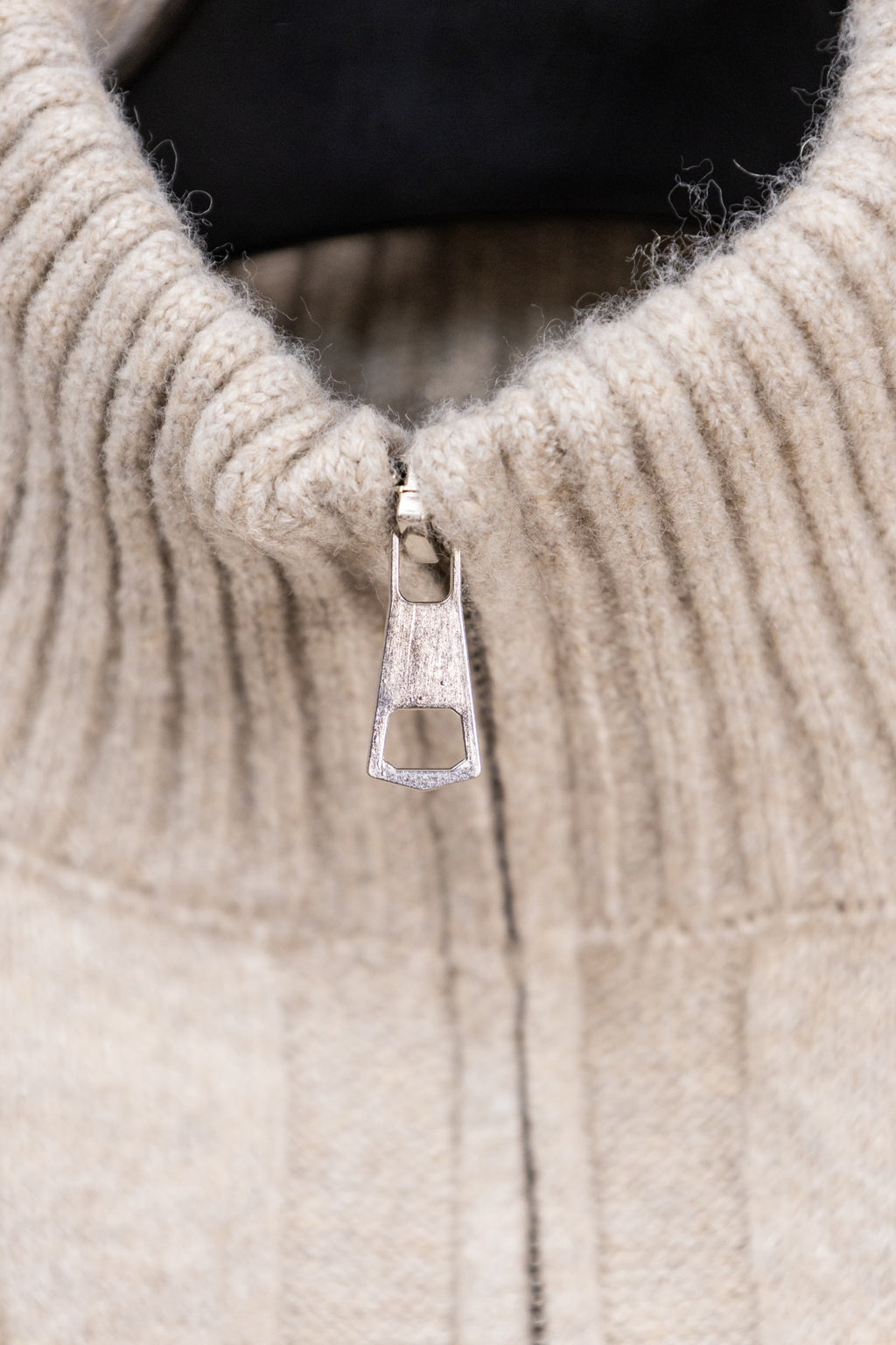 Cream knit sweater with stand collar and metal zipper pull detail