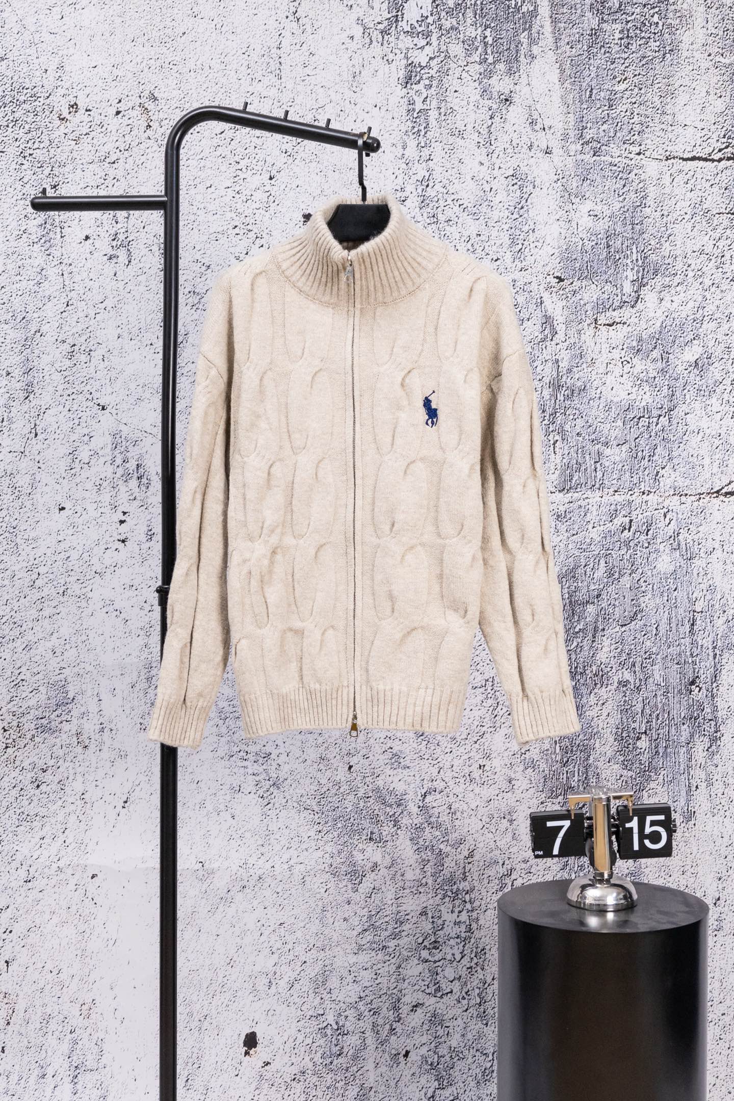 Cream knit zip-up sweater with stand collar and small blue polo logo