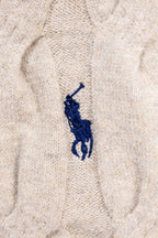 Cream knit sweater chest with small blue embroidered polo player logo