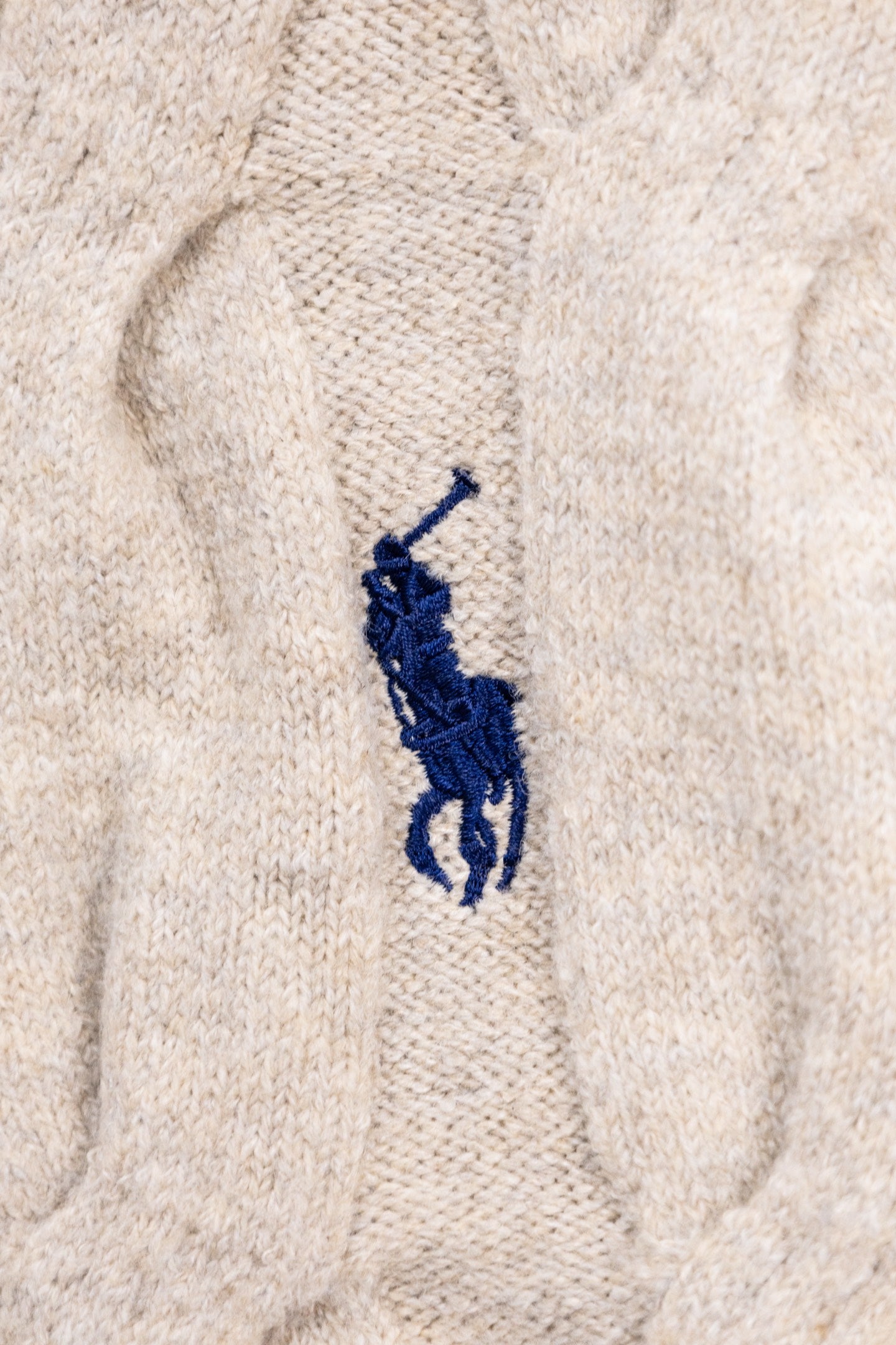 Cream knit sweater chest with small blue embroidered polo player logo