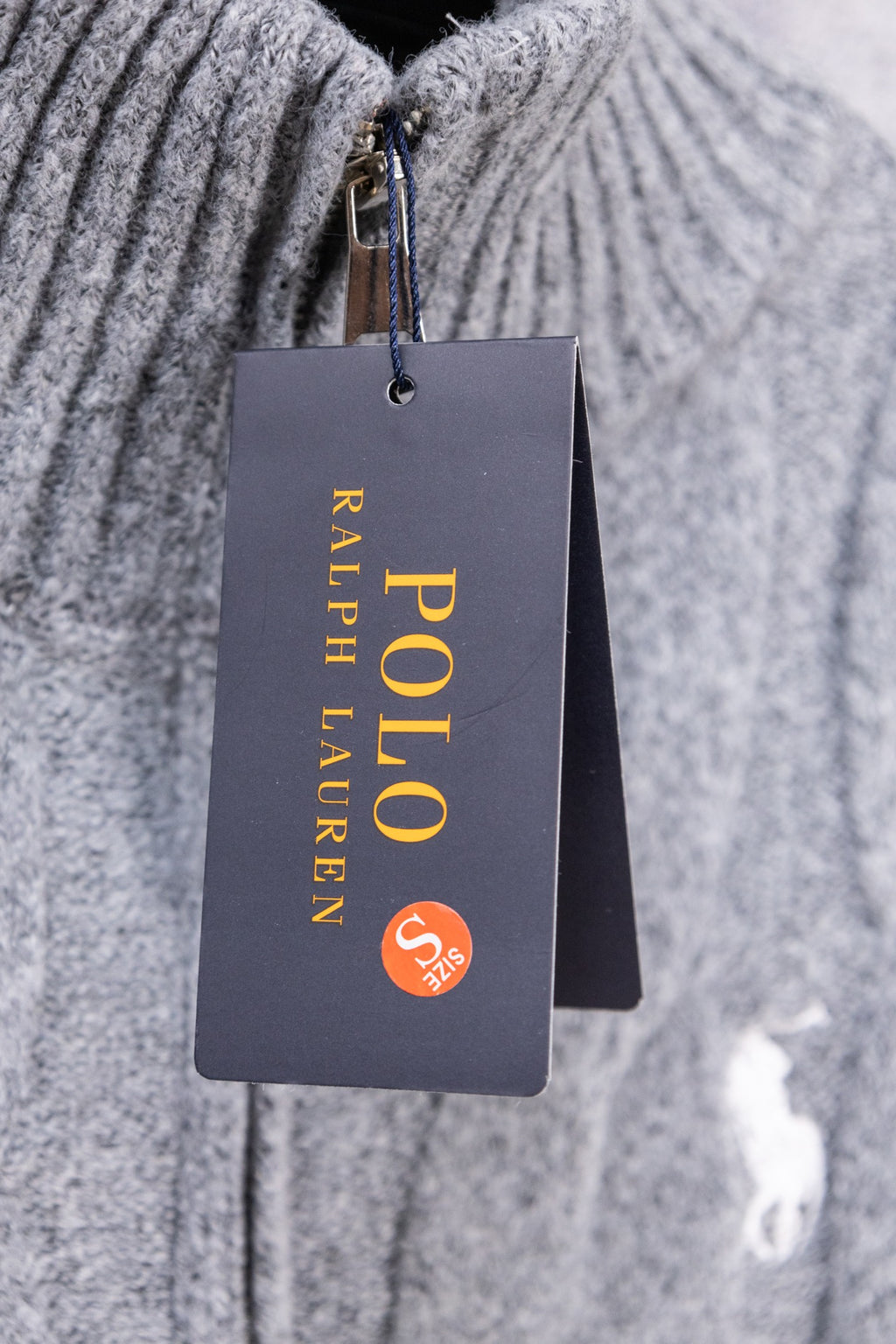 Heather gray knit sweater close-up with attached Ralph Lauren hang tag
