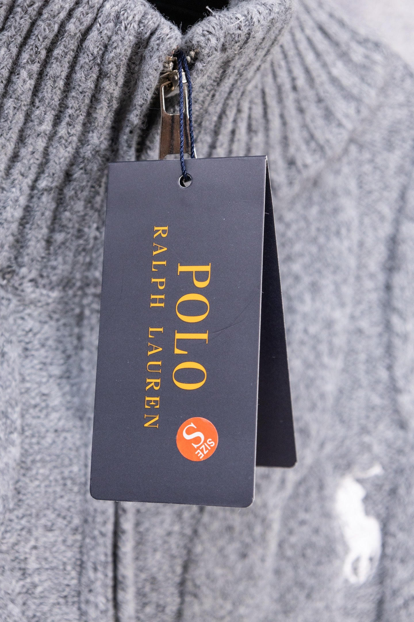 Heather gray knit sweater close-up with attached Ralph Lauren hang tag