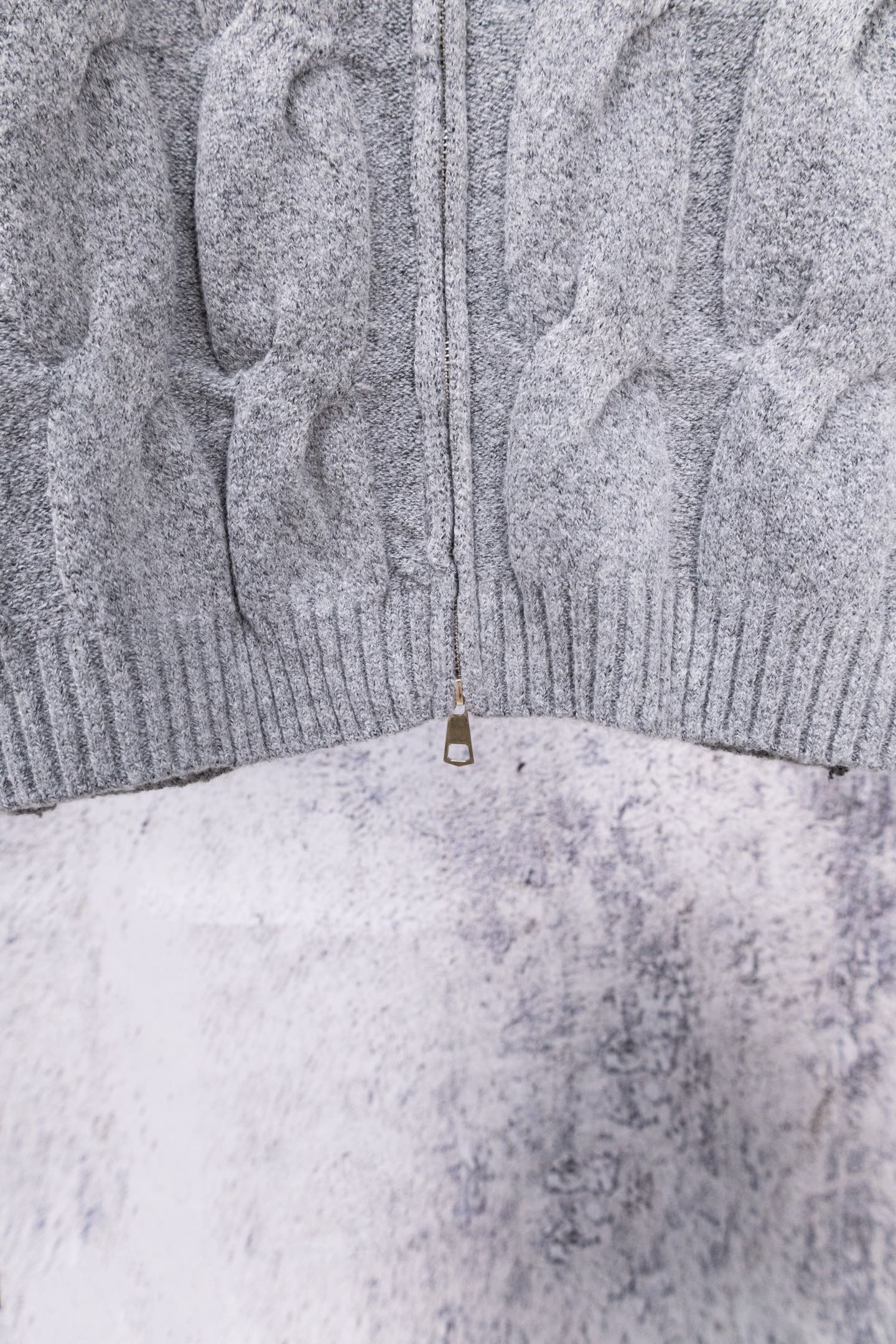 Heather gray knit sweater back hem with half-zip pull tab