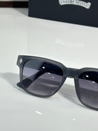 Black cat-eye sunglasses with dark lenses, close-up left frame