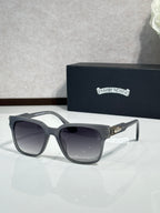 Black sunglasses with dark lenses and engraved temple branding, angled view