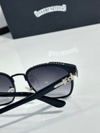 Sunglasses side close-up with dark lenses, black frame, logo temple and hinge