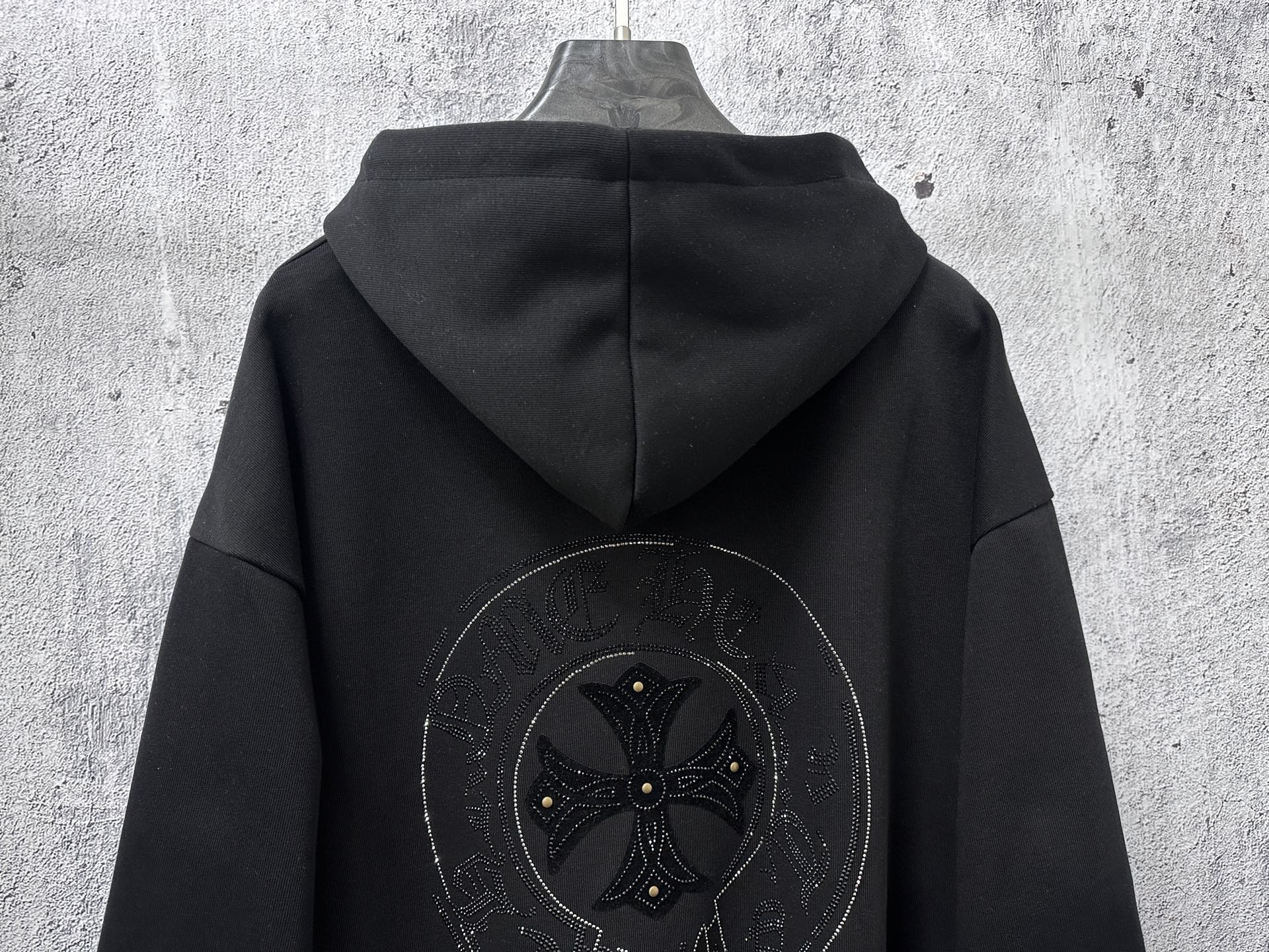 Black zip-up hoodie with rhinestone back graphic centered under hood
