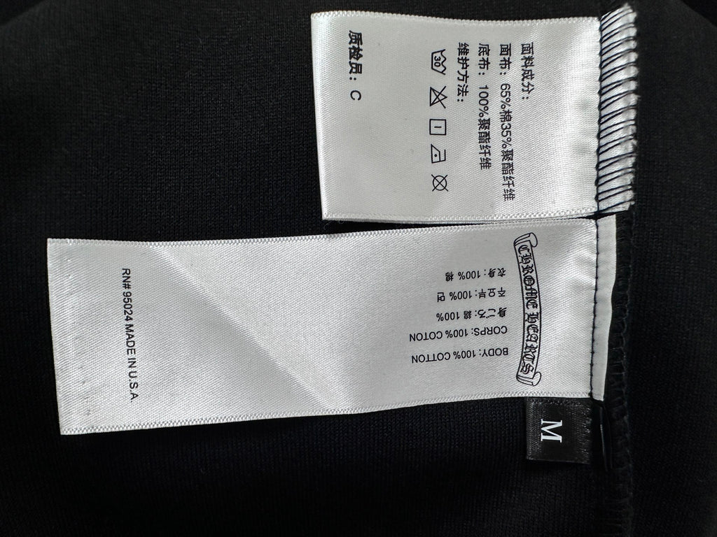 Black zip-up hoodie size label and care tags, marked M