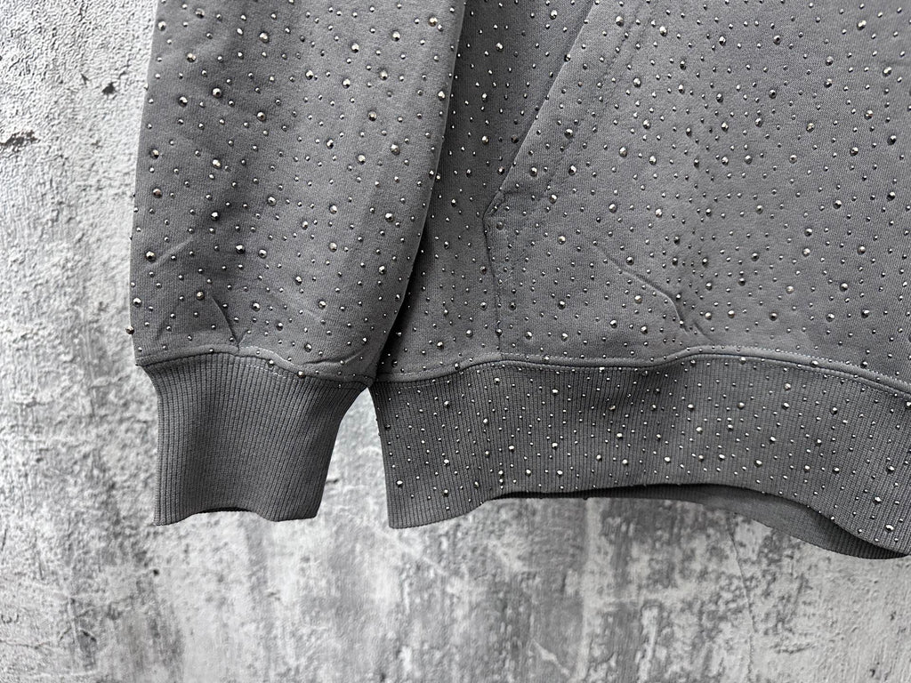 Long-sleeve hoodie cuffs and hem detail, dark gray with speckled dot pattern