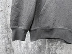 Long-sleeve hoodie cuffs and hem detail, dark gray with speckled dot pattern