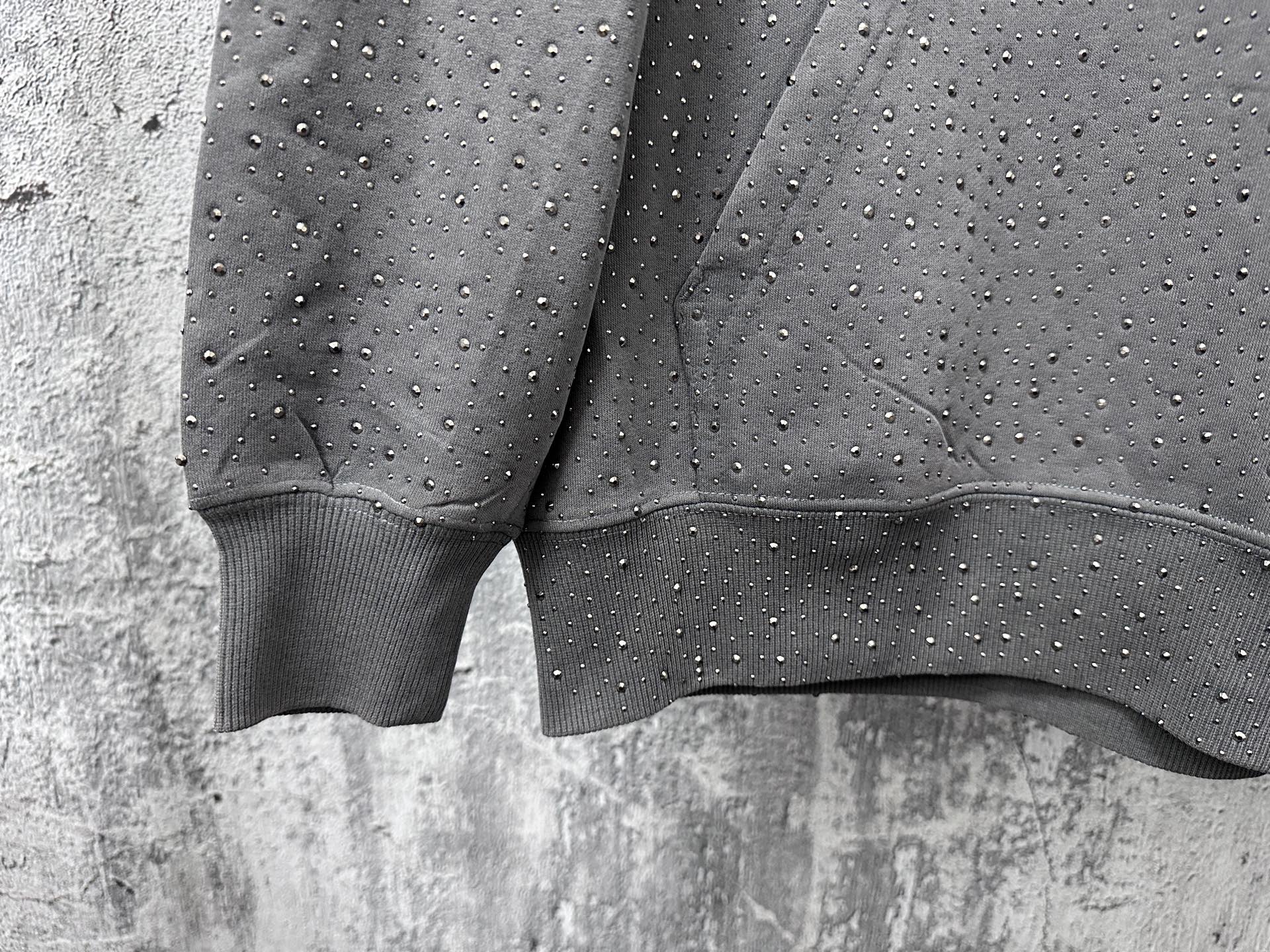 Long-sleeve hoodie cuffs and hem detail, dark gray with speckled dot pattern