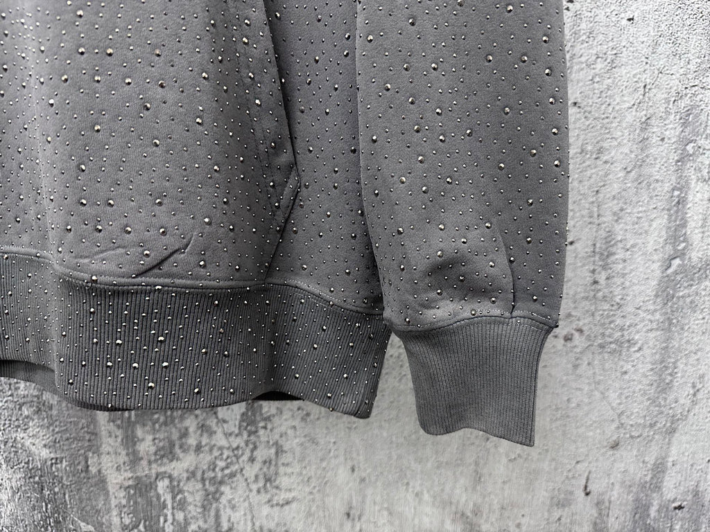 Long-sleeve hoodie sleeve and hem detail, dark gray with speckled dots