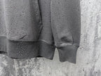 Long-sleeve hoodie sleeve and hem detail, dark gray with speckled dots
