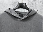 Long-sleeve hoodie with cowl hood, dark gray with speckled dots, front on hanger