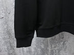 Black sweatshirt hem detail with ribbed cuffs and side seam