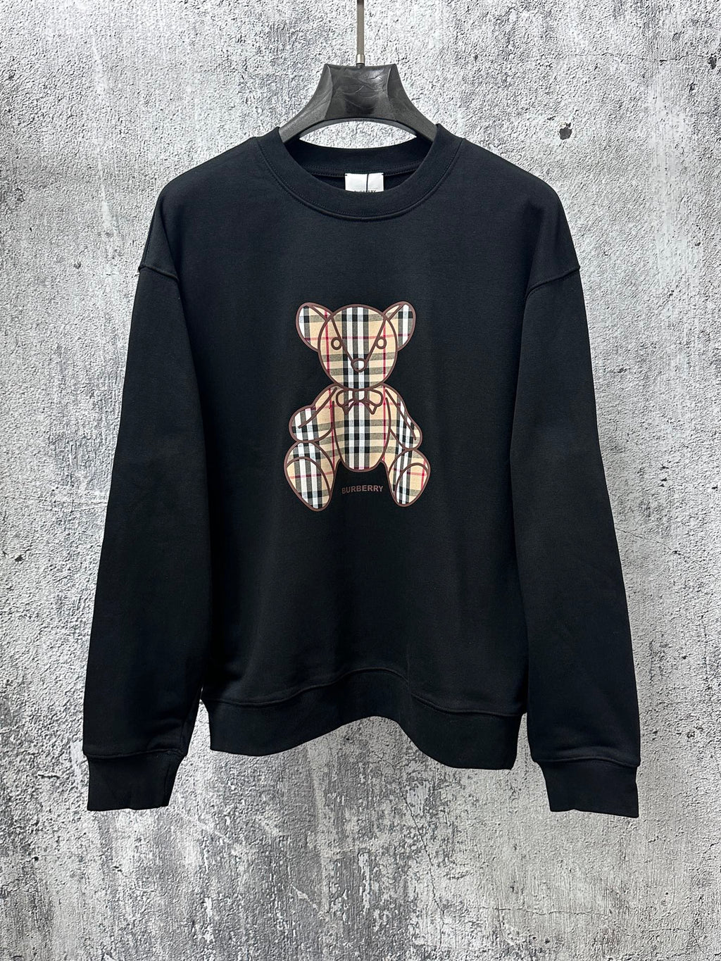 Black long-sleeve sweatshirt with plaid teddy bear graphic on front