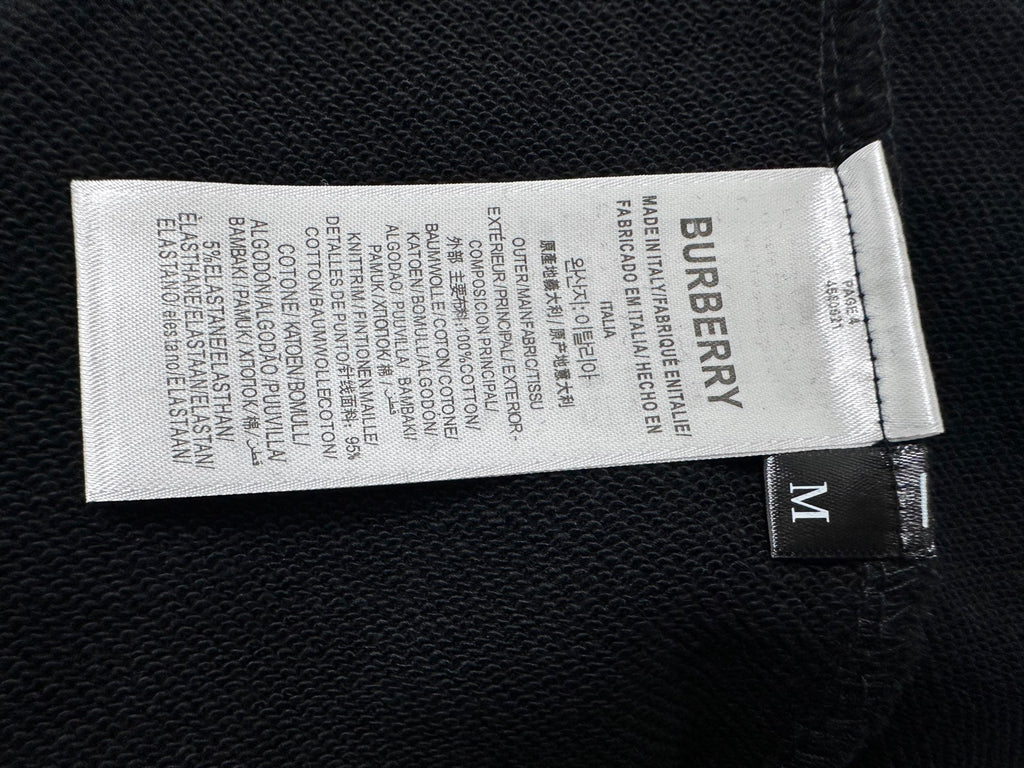 Burberry size and care label on black sweatshirt interior, size M tag