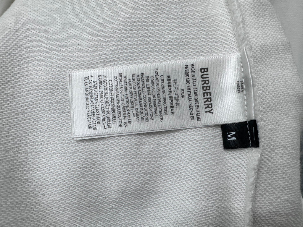 White sweatshirt fabric label reading Burberry with size M tag