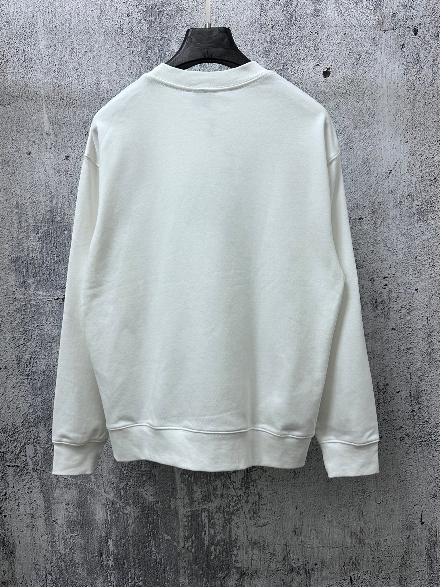 White crewneck long-sleeve sweatshirt, plain back view with ribbed cuffs