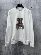 White crewneck long-sleeve sweatshirt with Burberry check-style teddy graphic on front
