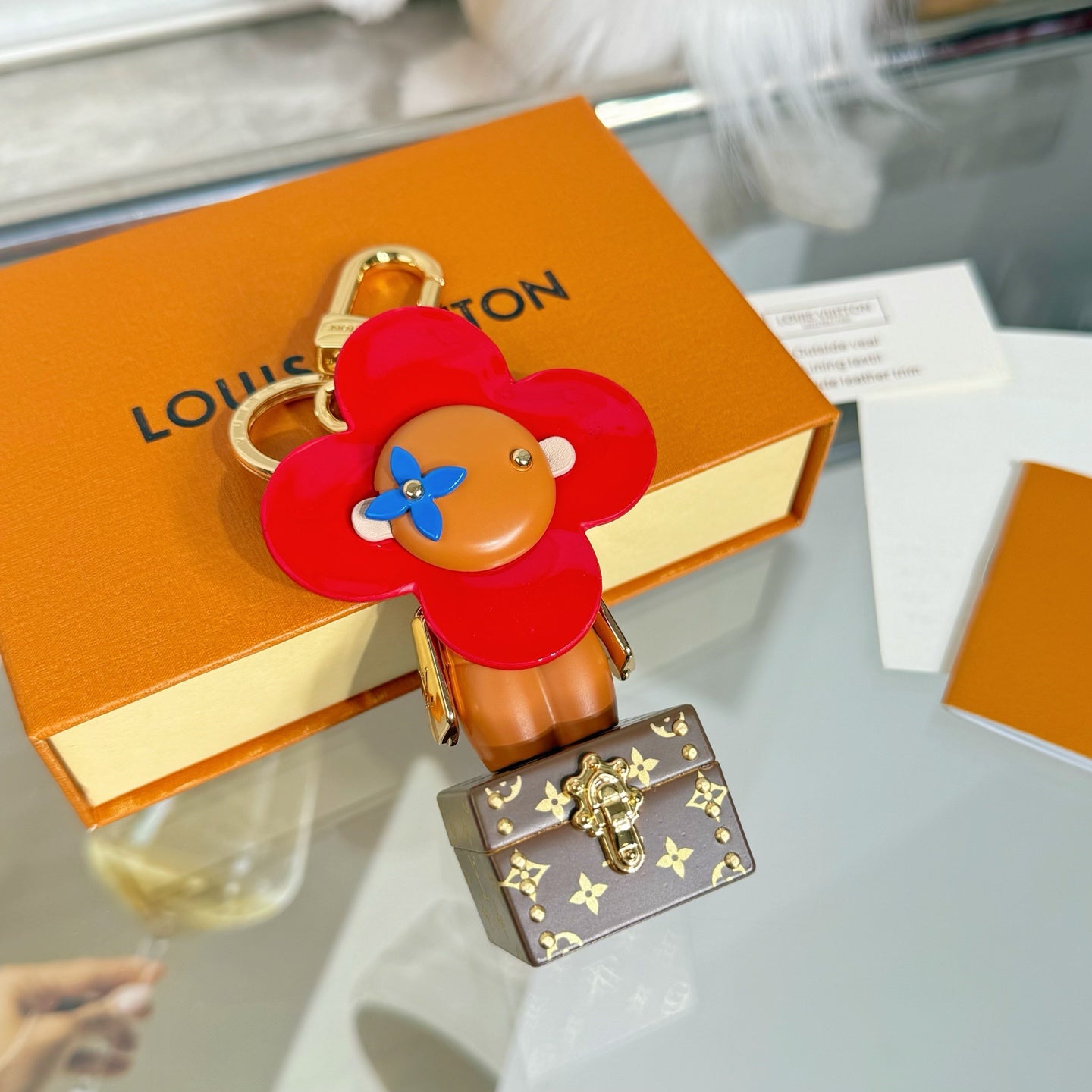 Louis Vuitton bear charm keychain with red flower head and brown monogram trunk