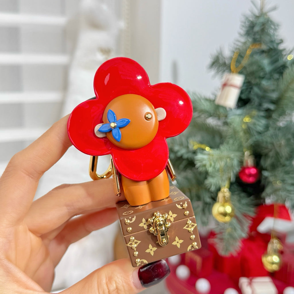 Louis Vuitton bear charm keychain held in hand, red flower head and brown trunk
