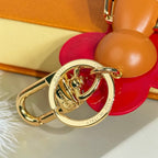 Louis Vuitton gold keyring charm with red flower bear, tan leather body