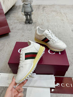 White Gucci leather sneakers with green-red stripe, lace-up style, yellow rubber sole